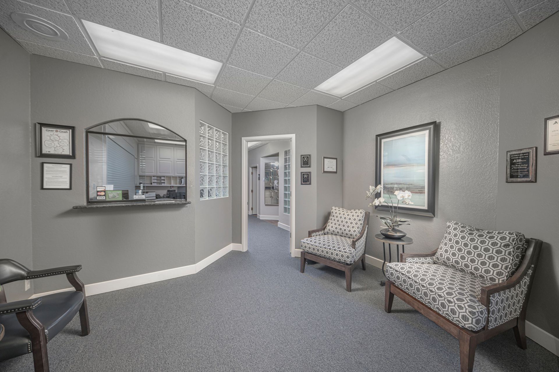 A waiting room with chairs and a counter in a dental office.