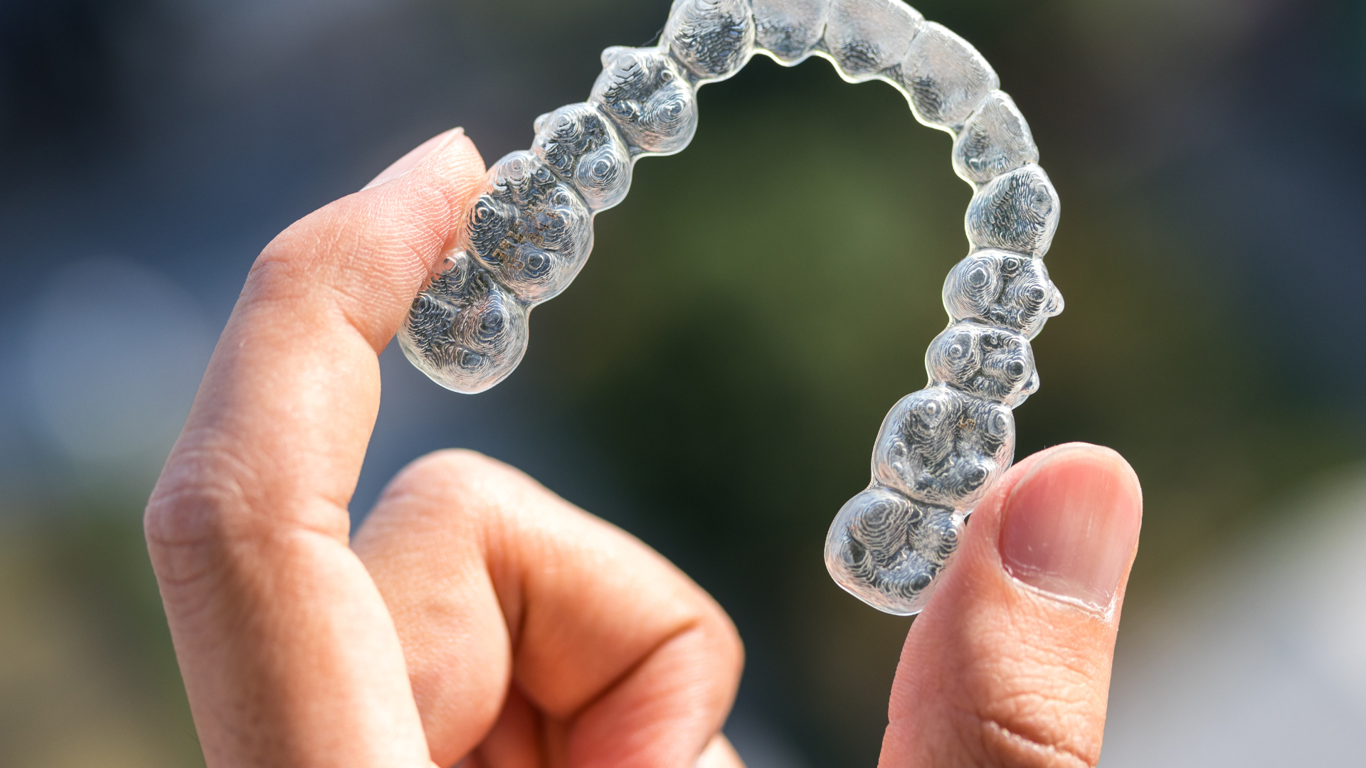 a person is holding a clear brace in their hand .