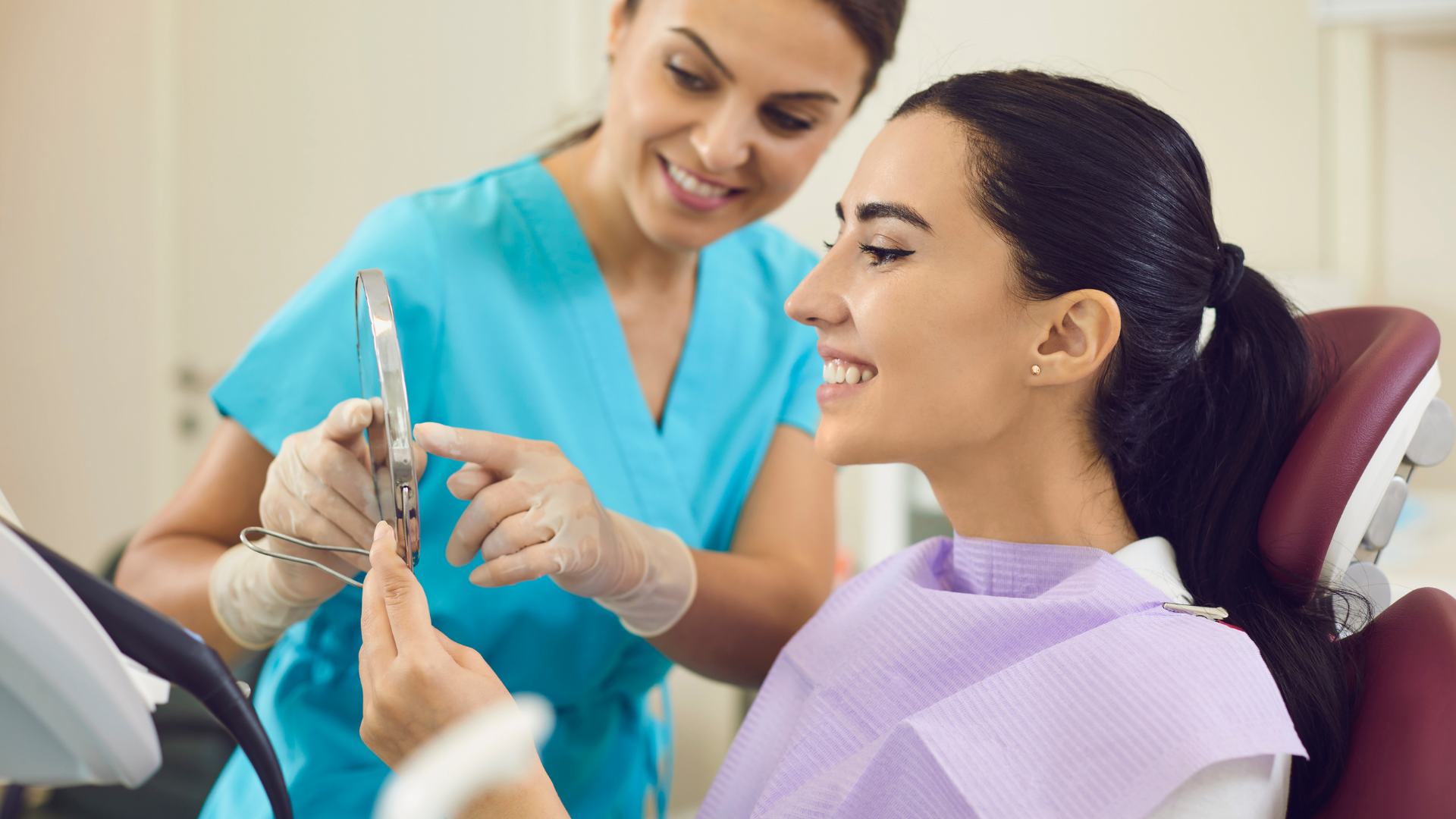 A man with a beard is smiling while holding a tooth color chart.