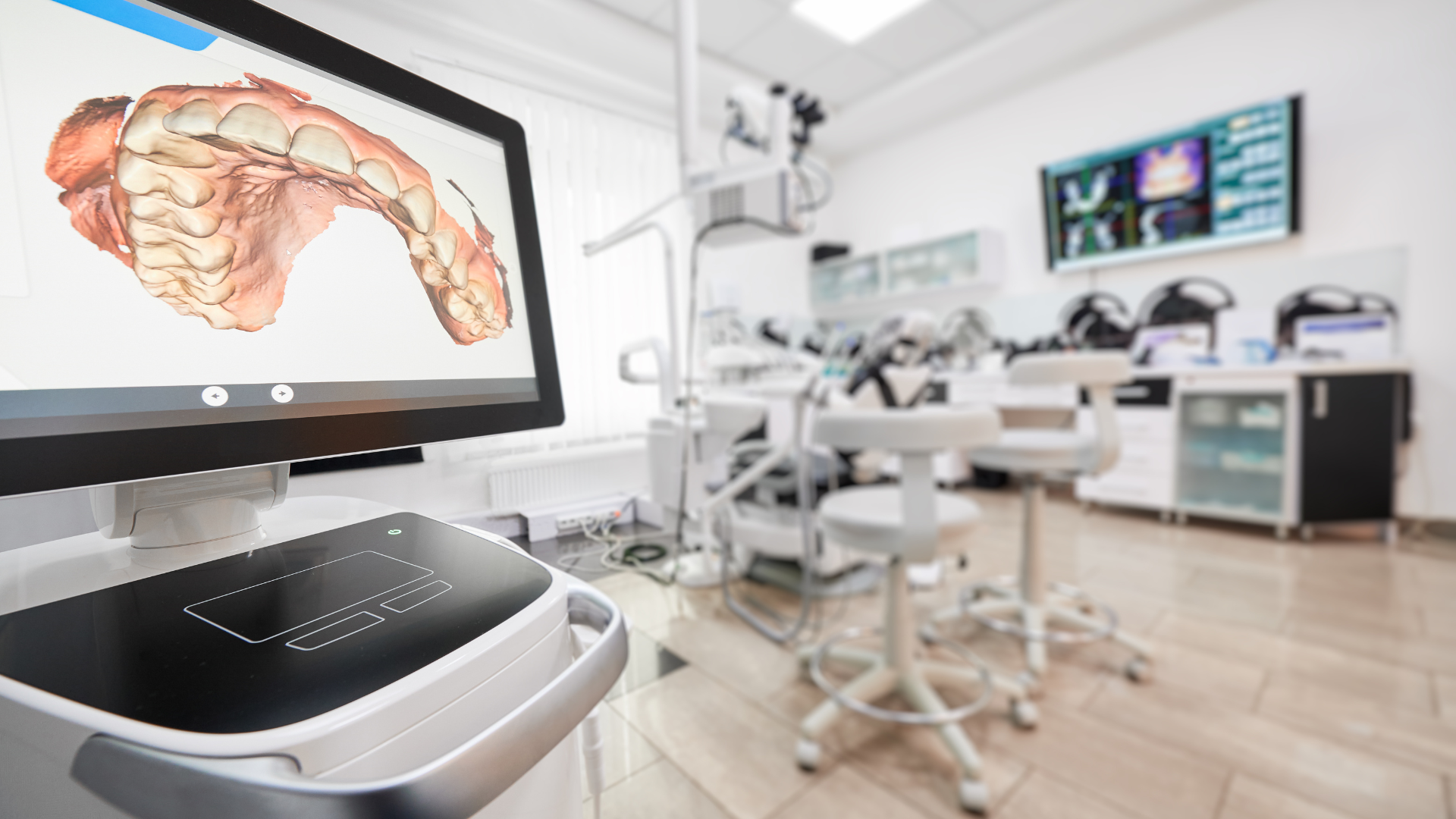 a computer monitor is sitting in a dental office next to a dental chair .