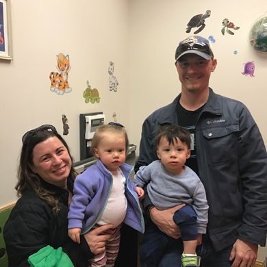 Family with parents and two children in pediatrician's office