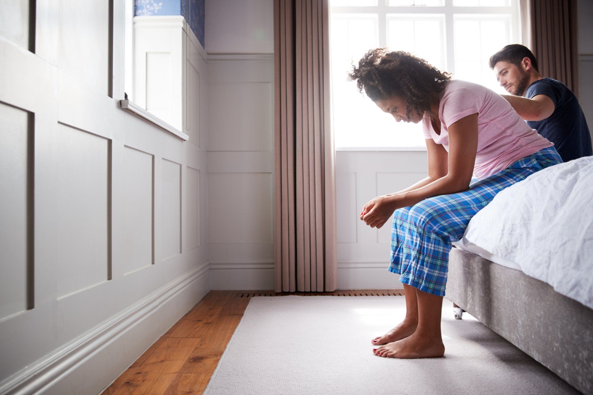 disappointed woman sitting on the edge of the bed
