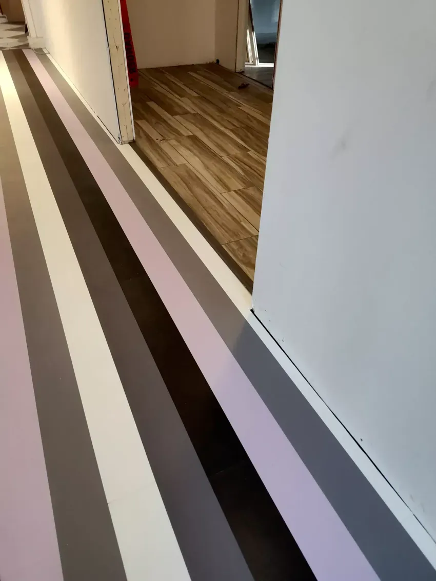 Light brown wood-look plank flooring with a diagonal pattern and subtle grain texture.