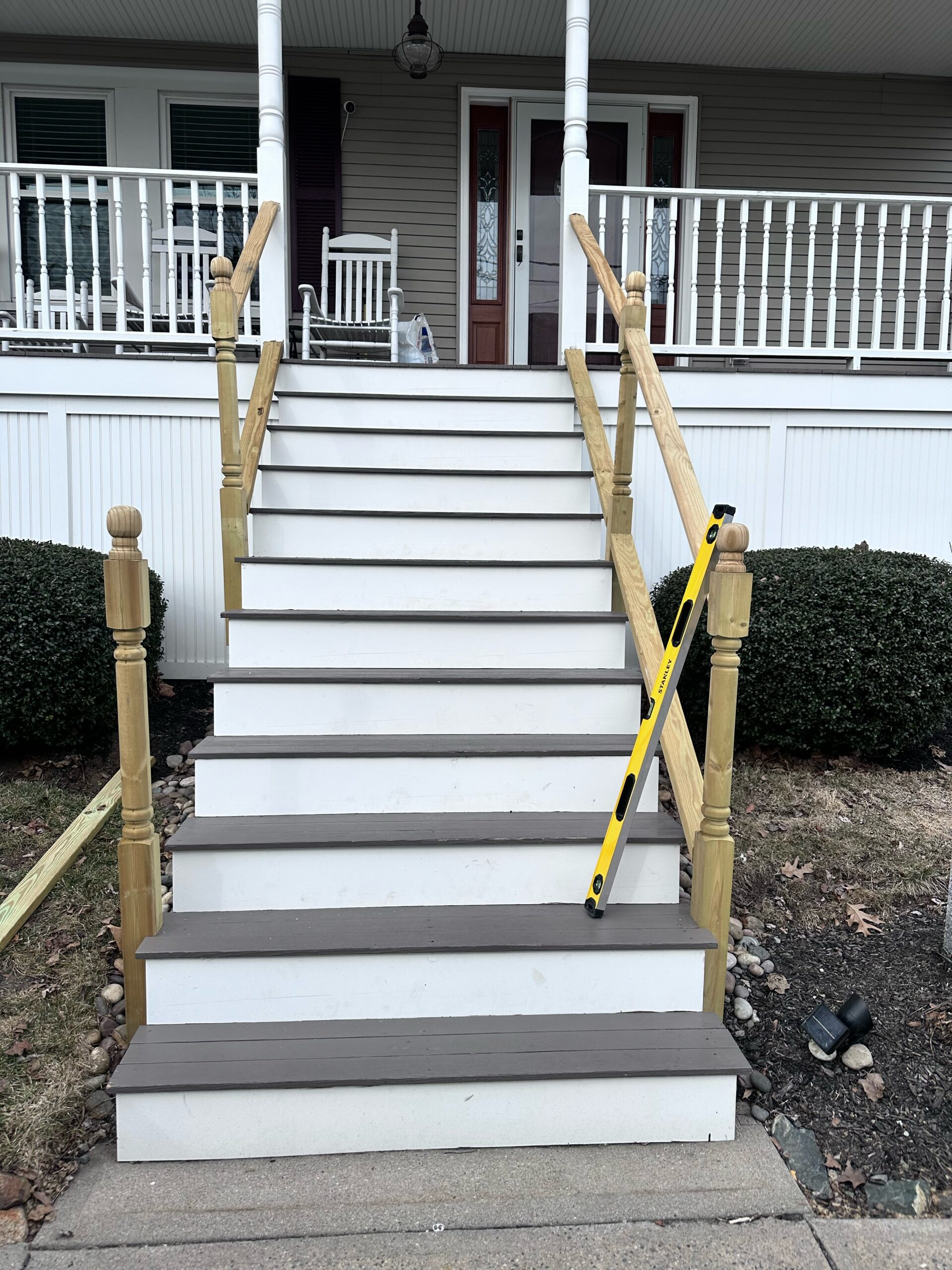Front porch stairs with yellow handrails and black-and-yellow caution tape blocking access.