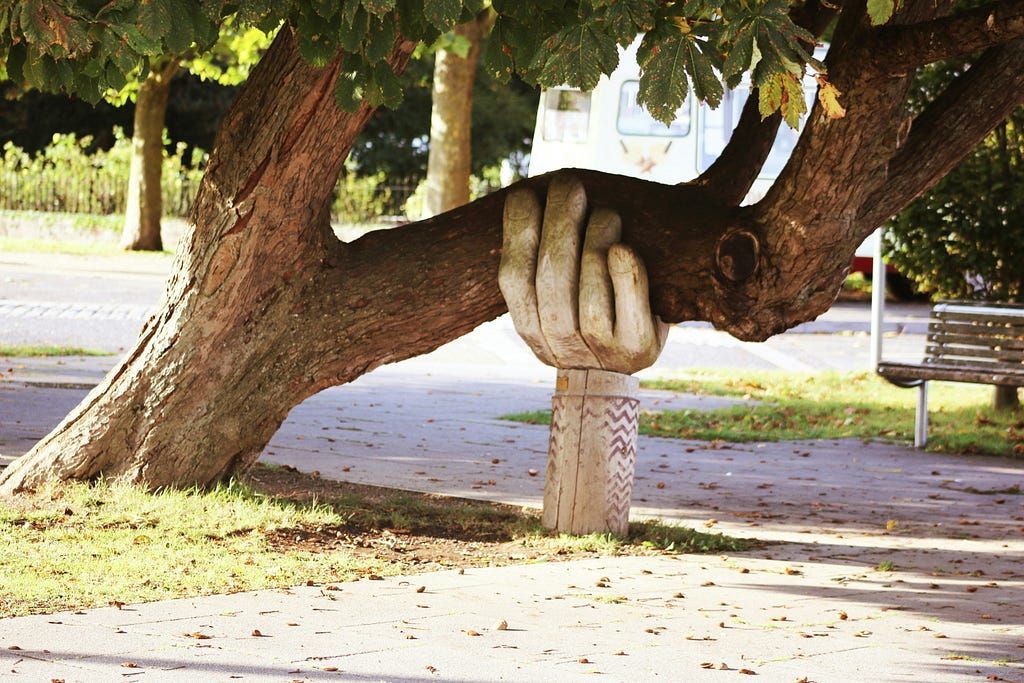 A statue of a hand holding a tree branch