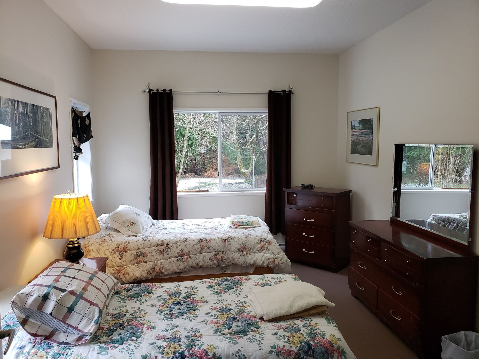 A bedroom with two beds and a dresser
