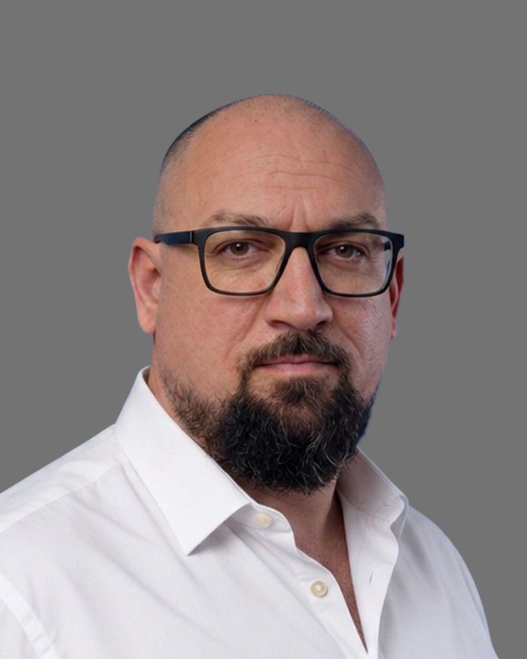 A man with a beard wearing glasses and a white shirt