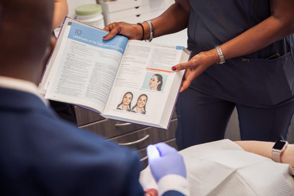 students looking at book during training class | radiology and dental assistant training in Villa Rica GA