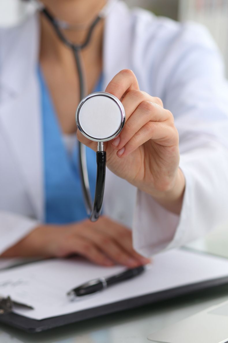 Médico segurando o estetoscópio, pronto para examinar um paciente.