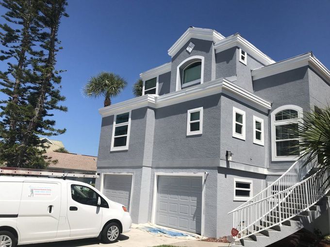 A white van is parked in front of a large house