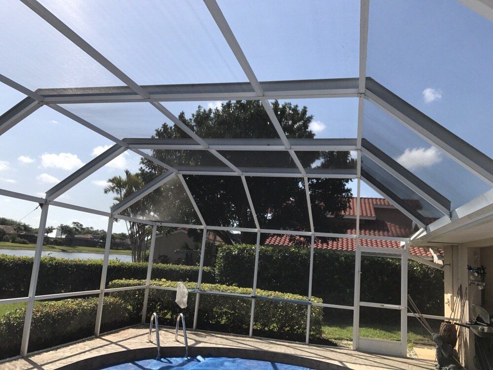 A screened in swimming pool with a clear roof