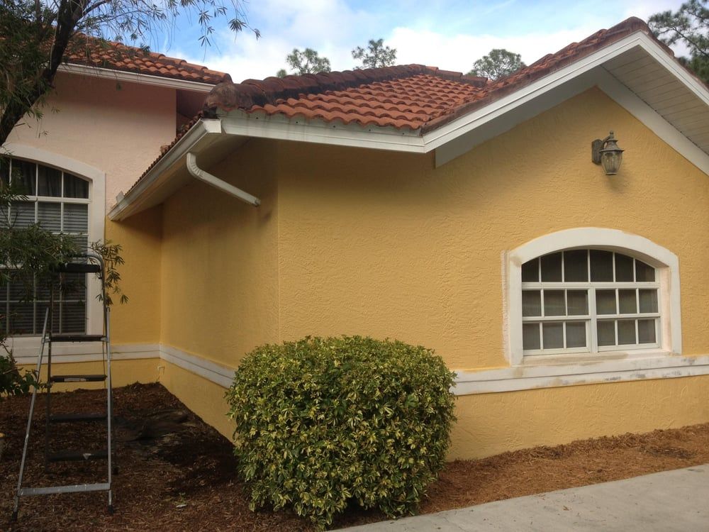 A yellow house with a ladder in front of it