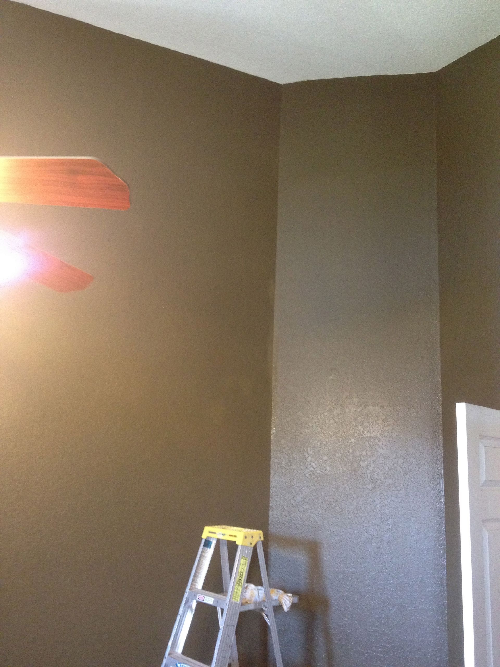 A room with a ladder and a fan on the ceiling