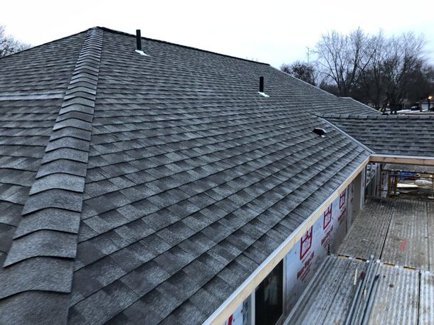 A roof with a lot of shingles on it is being built.