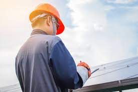 Man in a hard hat inspecting a roof.