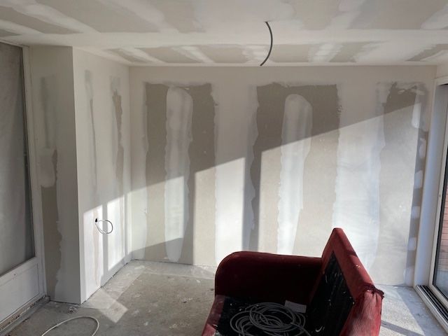 Un salon avec un canapé rouge et des murs blancs.