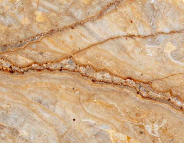 Primo piano di marmo beige con venature ondulate color sabbia e marrone