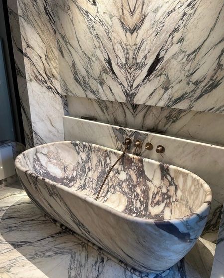 Bagno moderno beige con mobile sospeso in pietra, grande specchio e vasca freestanding