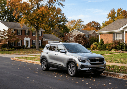 Silver SUV parked on a residential neighborhood street lined with homes, trees, and autumn foliage.