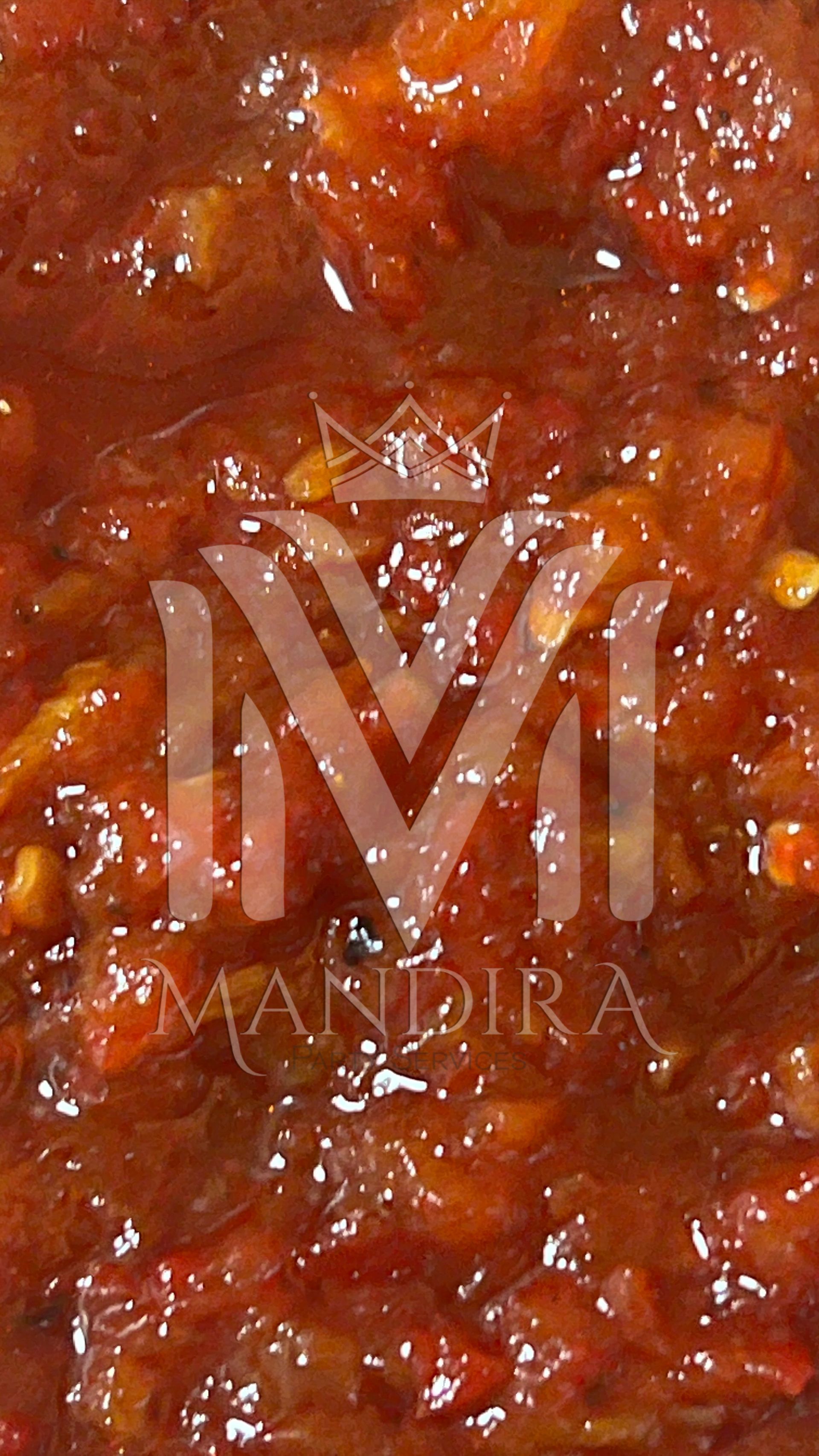 Close-up van Mandira-chutney, een dikke, rode substantie met zichtbare zaadjes.