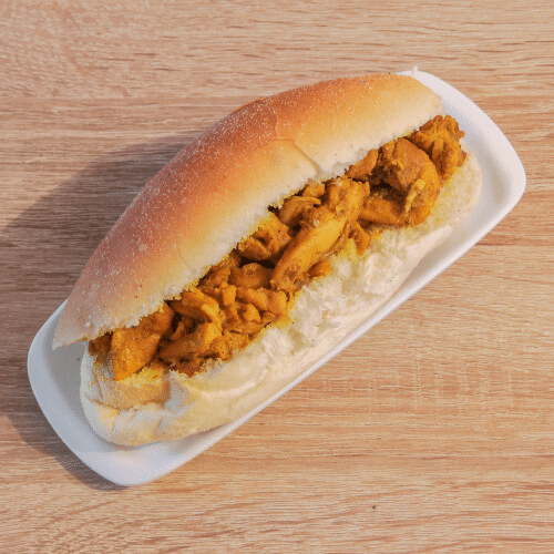 Kipsandwich op een wit bord, op een houten tafel.