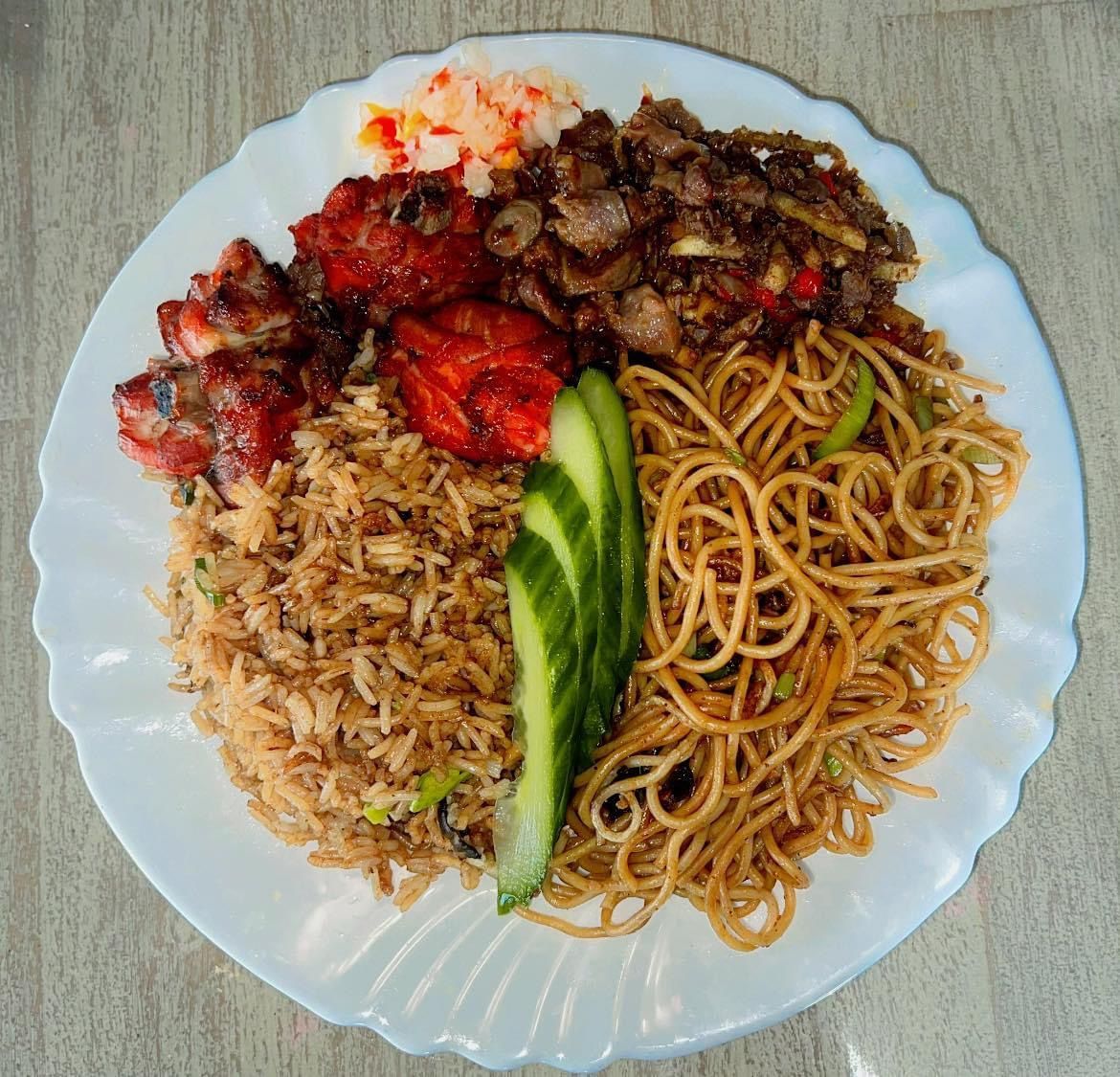 Een bord Chinees eten: gebakken rijst, noedels, vlees en groenten.