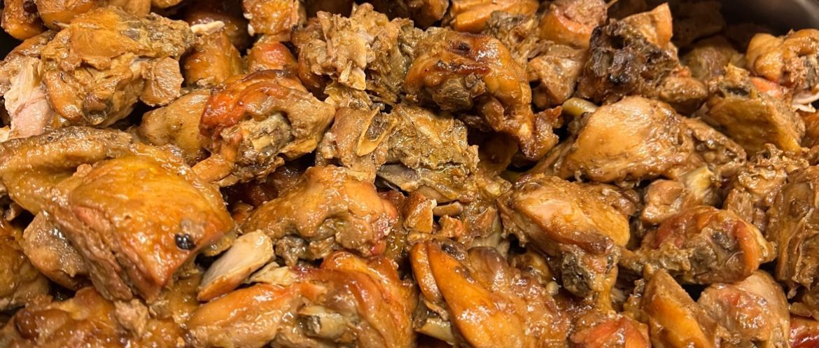 Close-up van gekookte kipstukjes in een hartige saus.