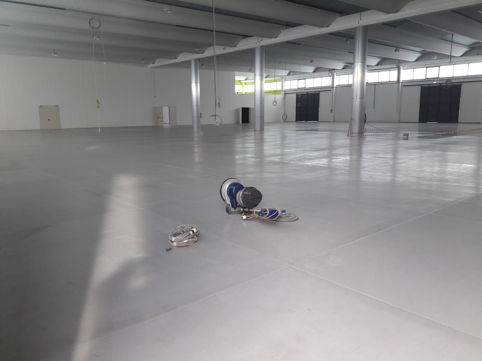 Empty warehouse with a helmet and small items on a concrete floor