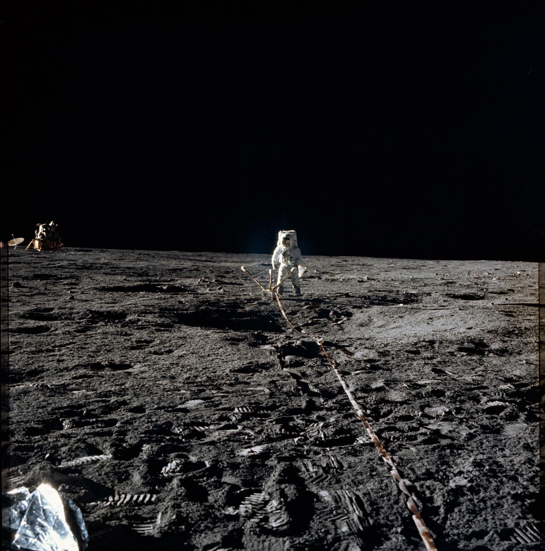 An Apollo 12 astronaut deploying an experiment package on the lunar surface