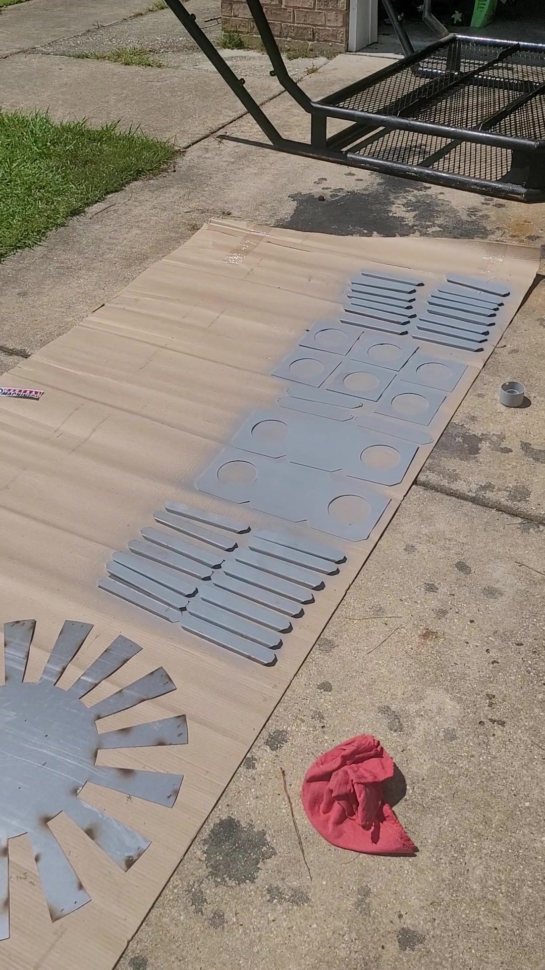 Cut steel blades laid out beside a welded frame outside the Hephaestus shop