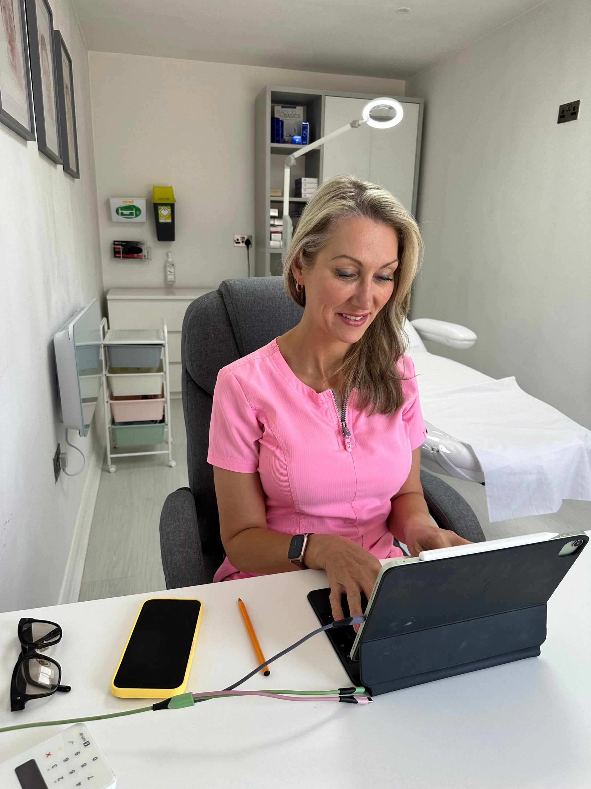 A woman is sitting at a desk using a laptop computer.