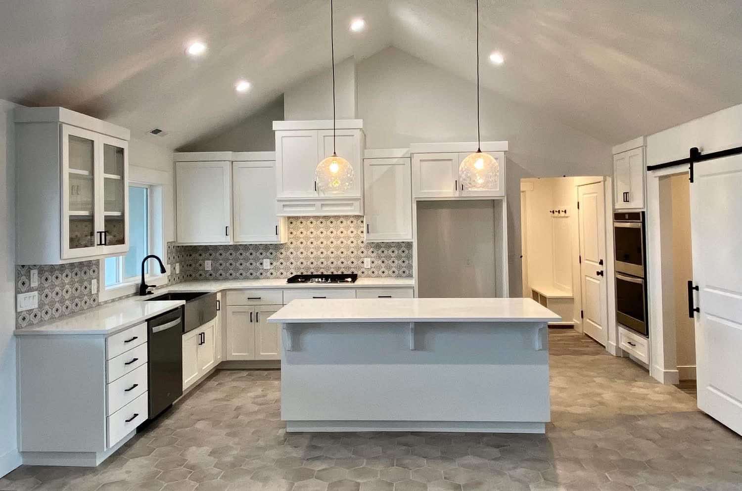 A kitchen with white cabinets , stainless steel appliances , and a large island in Beaver Utah