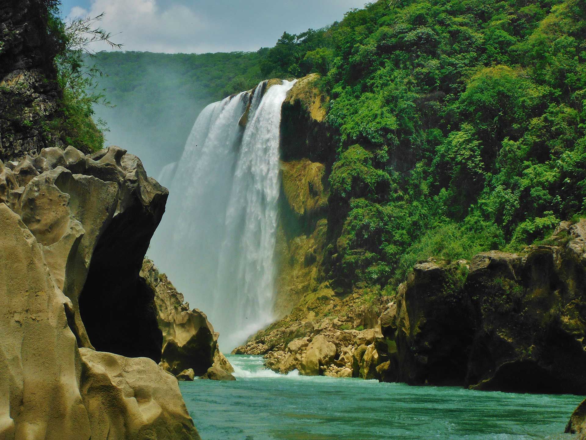 Una persona practica paddleboard frente a una gran cascada.