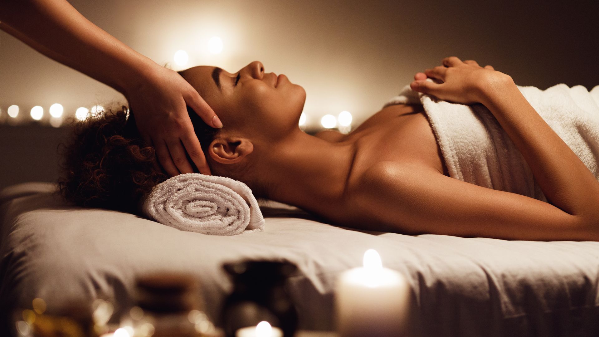 A woman is getting a head massage at a spa.