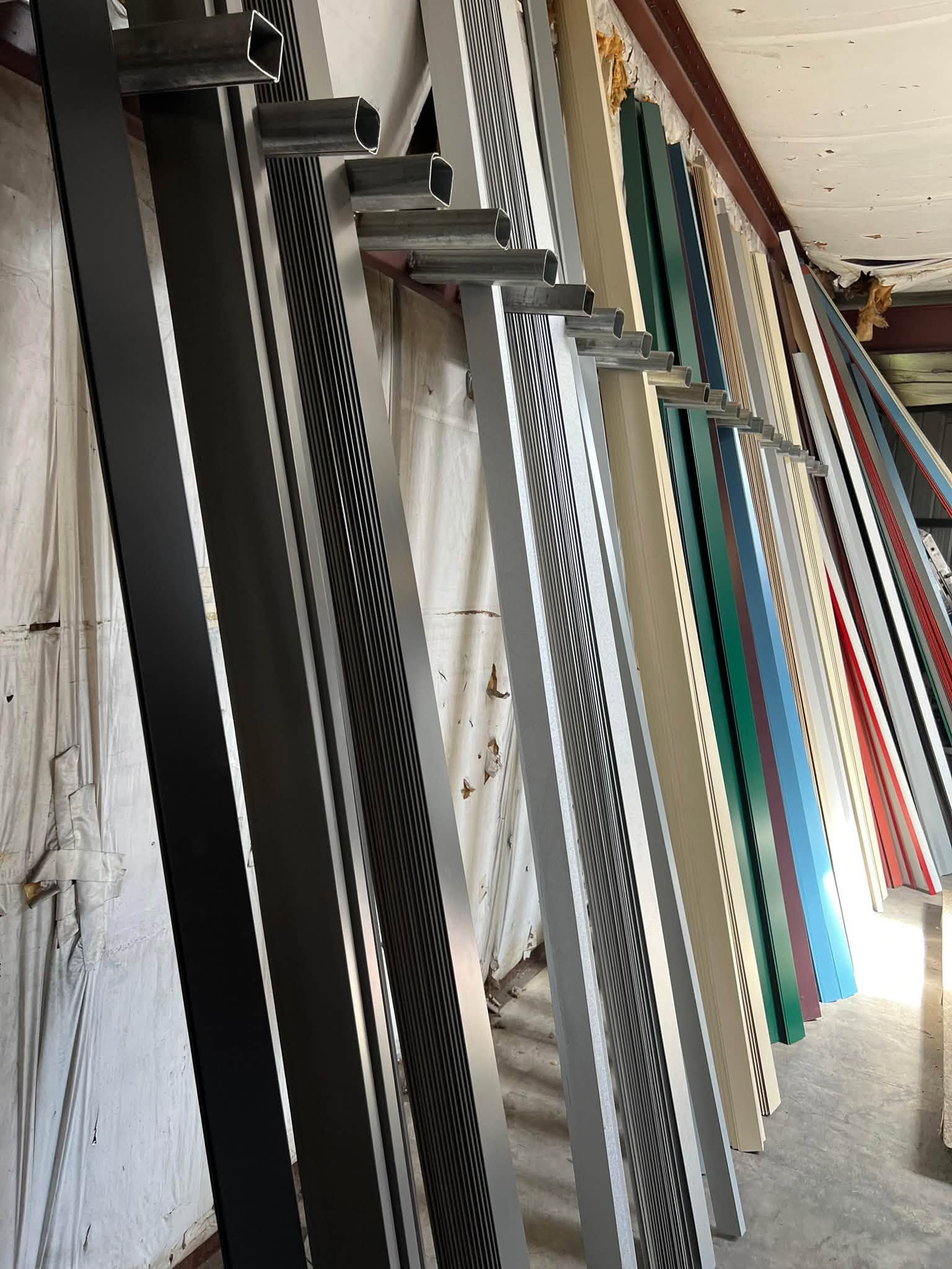 Stacked metal frames and panels leaning against a wall in a narrow corridor.