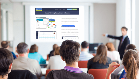 A man is giving a presentation to a group of people in a classroom.
