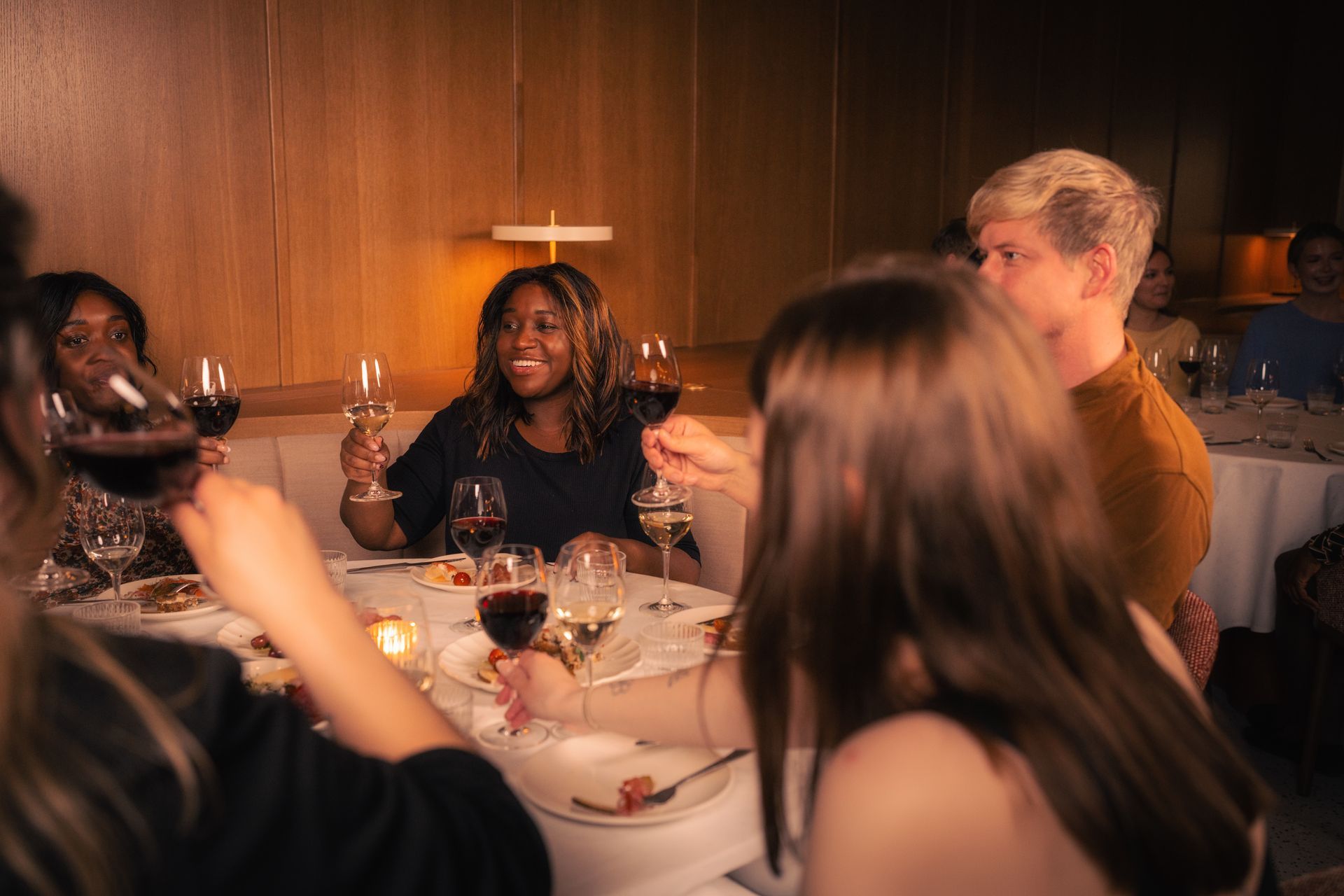 Koselig arrangementlokale med stort marmorbord, lenestoler, sofa, mat og drikke for selskap
