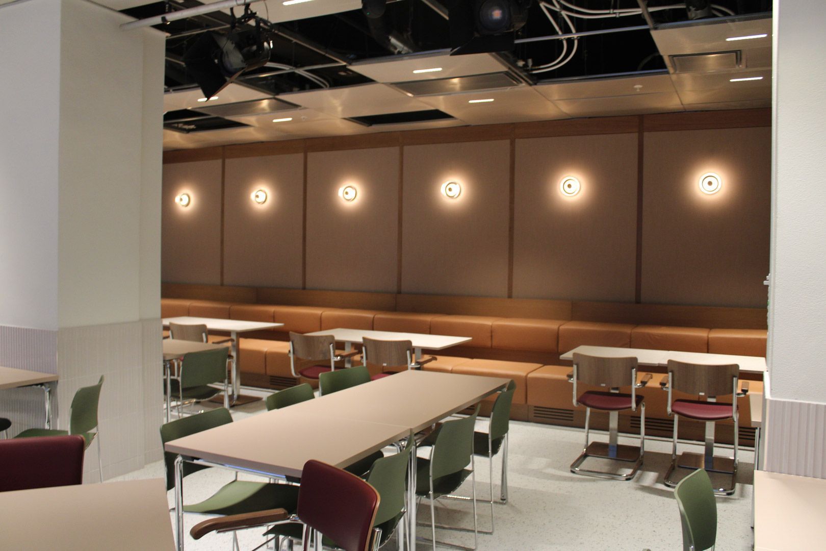 Moderne kafé sittegruppe med bord, stoler og varme vegglamper