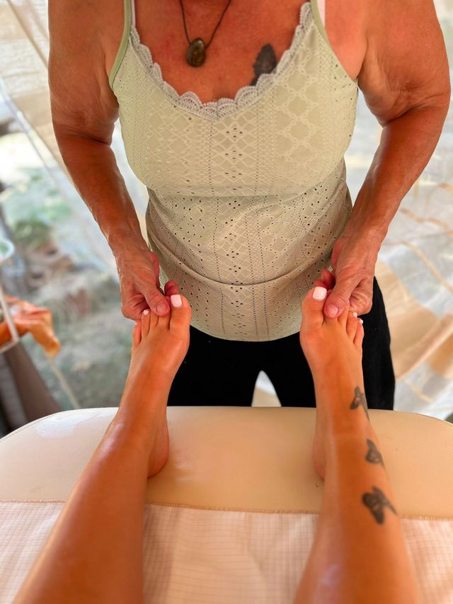 Una persona riceve un massaggio alla schiena in una spa. Un massaggiatore esercita una pressione con le mani.
