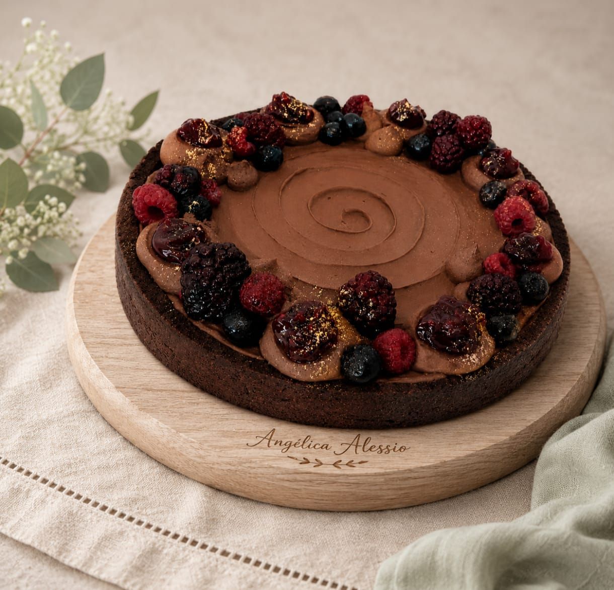 Tarta de chocolate cubierta con frutos rojos e higos sobre una tabla de madera.