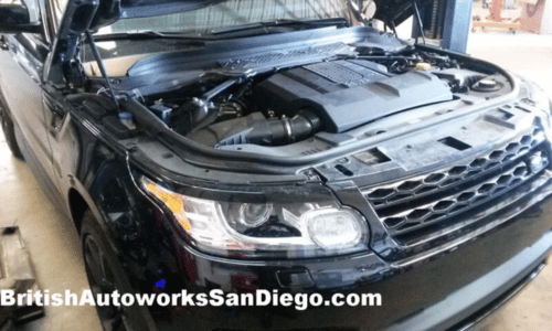 Black SUV with open hood in a workshop, showing the engine bay and front grille.