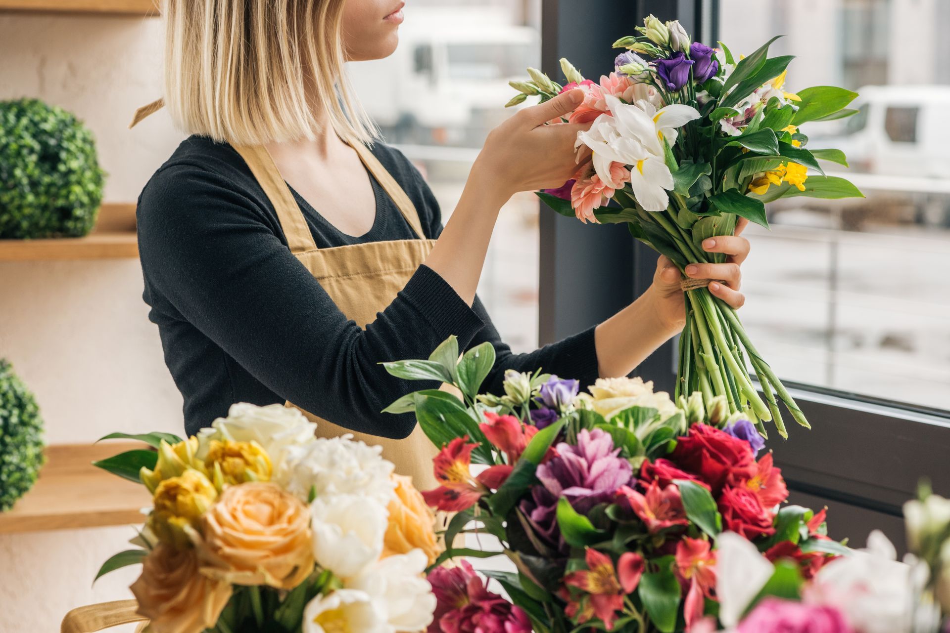 Florist arranging a fresh flower bouquet in a flower shop