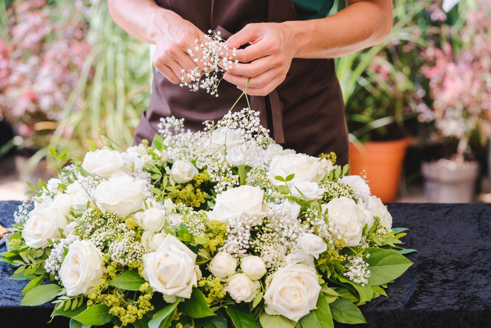 A florist is arranging a circular wreath.