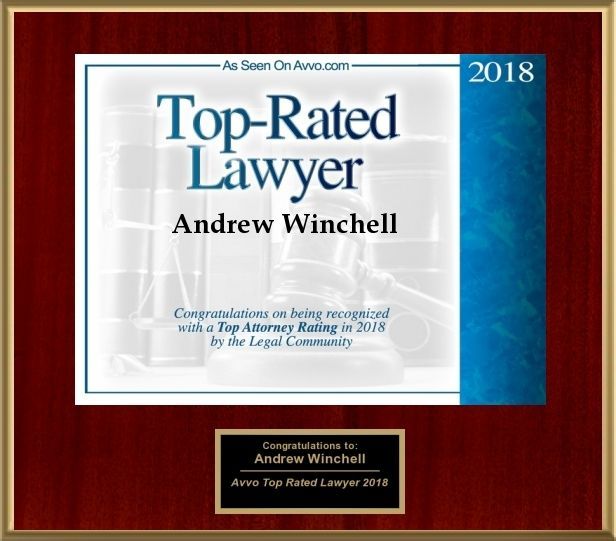 2018 Top-Rated Lawyer award plaque for Andrew Winchell on a red wood background
