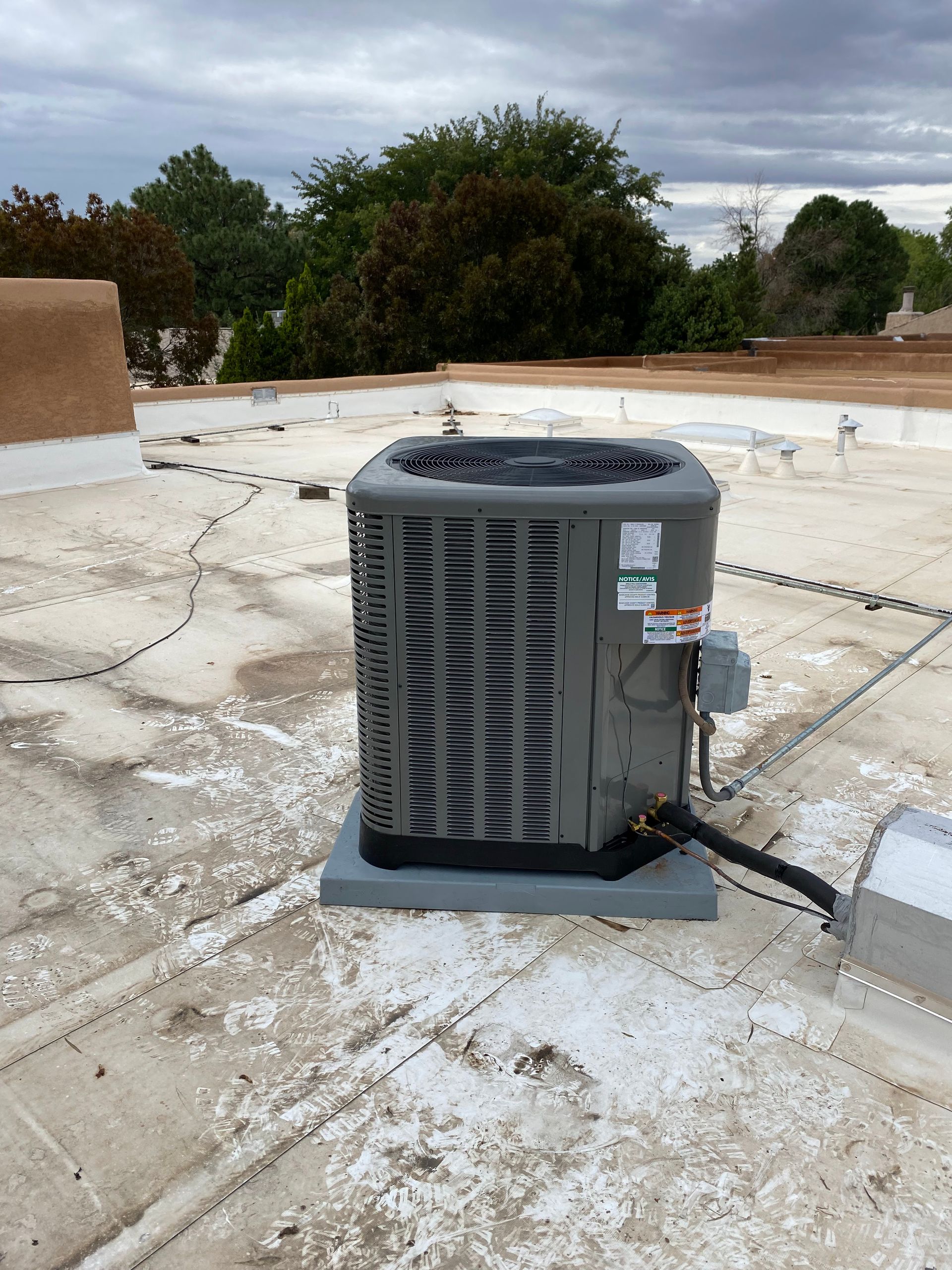 An air conditioner is sitting on top of a roof.