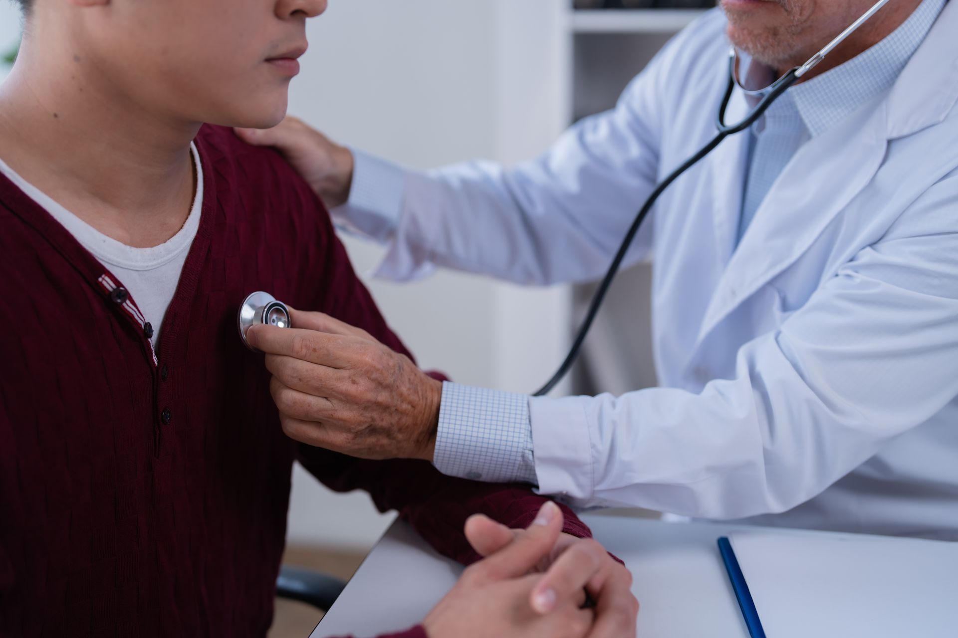 Doctor checking a young man's chest with a stethoscope. Doctor checking a young man's chest with a stethoscope.