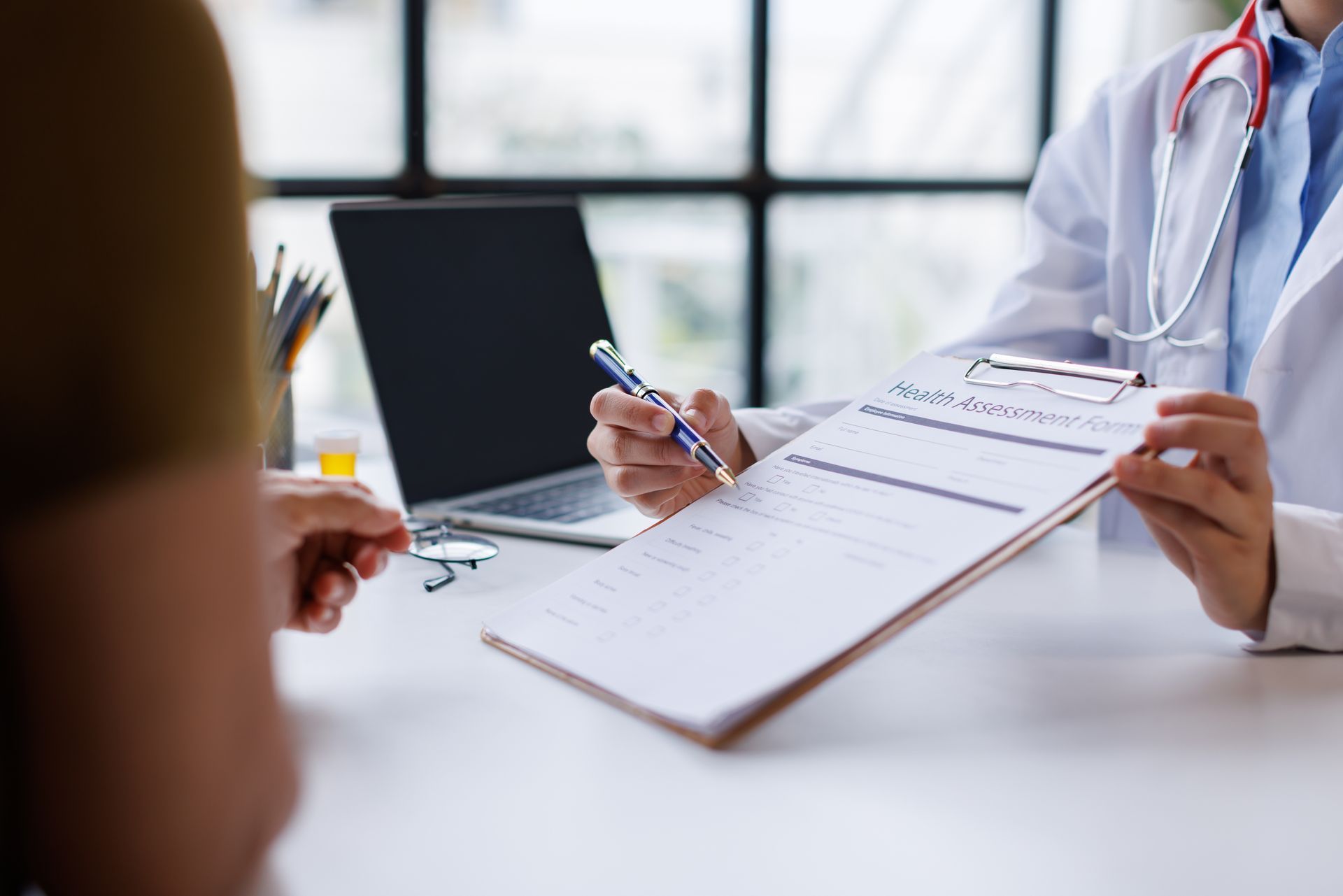 Doctor discussing health assessment form with patient during medical consultation. Doctor discussing health assessment form with patient during medical consultation.