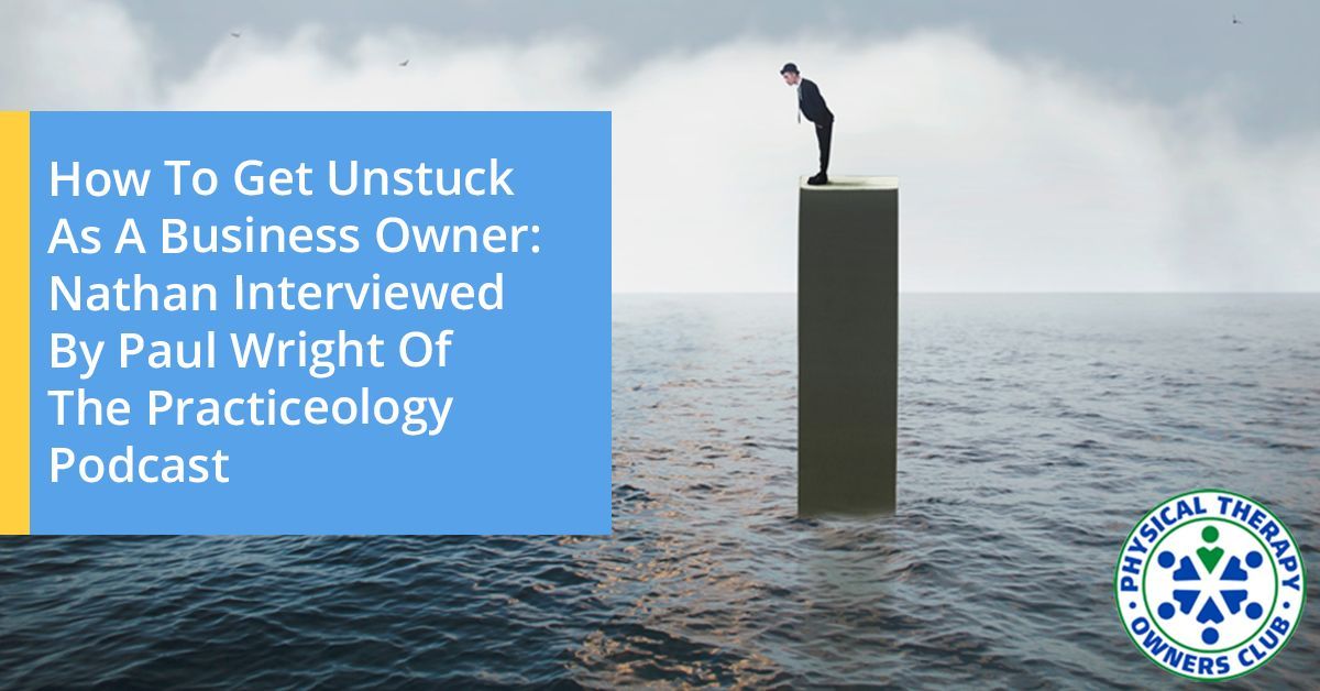 A man is standing on top of a block in the middle of the ocean.