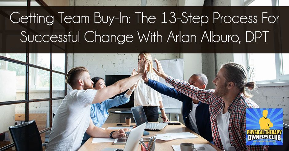A group of people are giving each other a high five while sitting around a table.