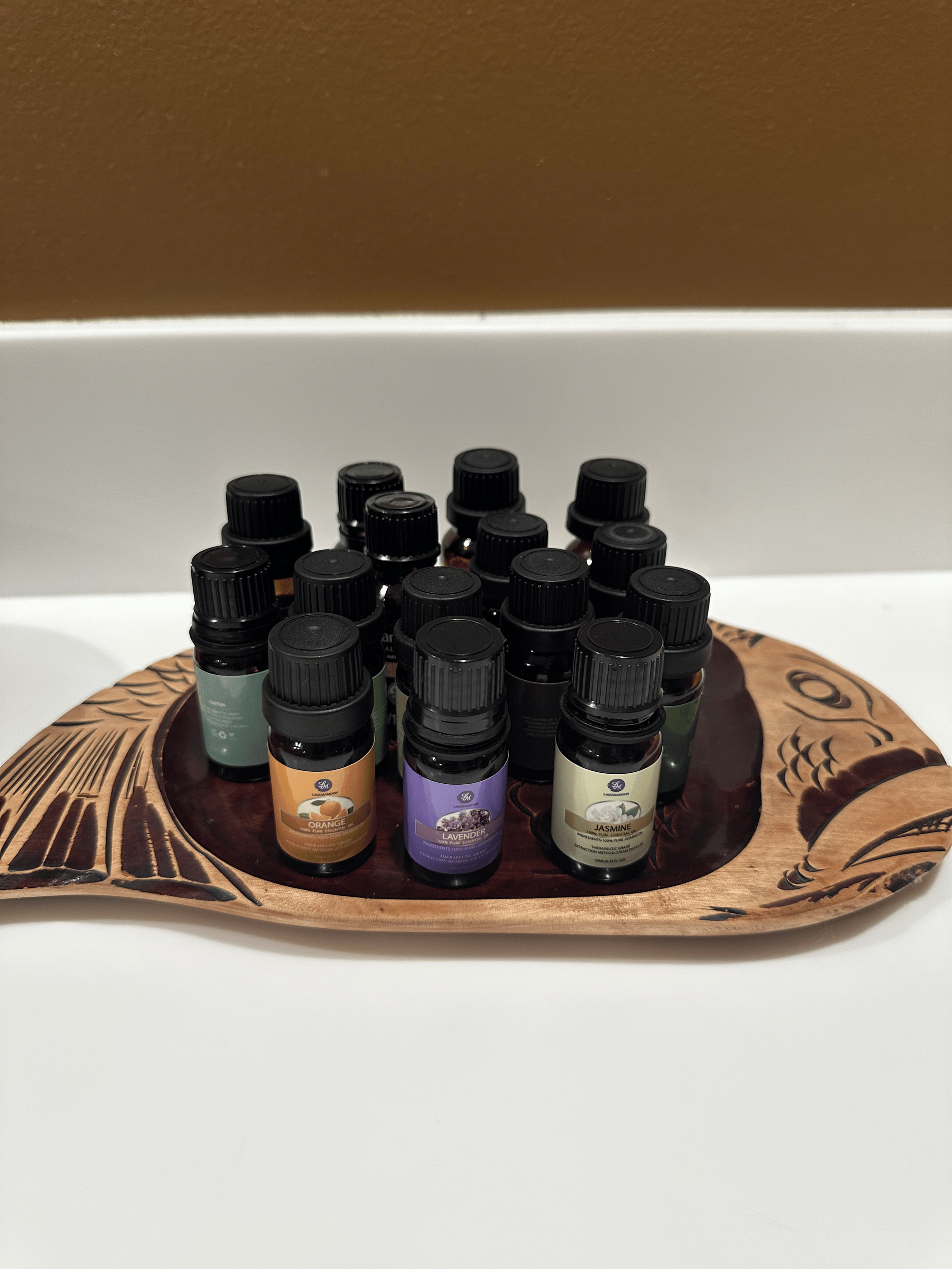 A wooden spoon filled with bottles of essential oils